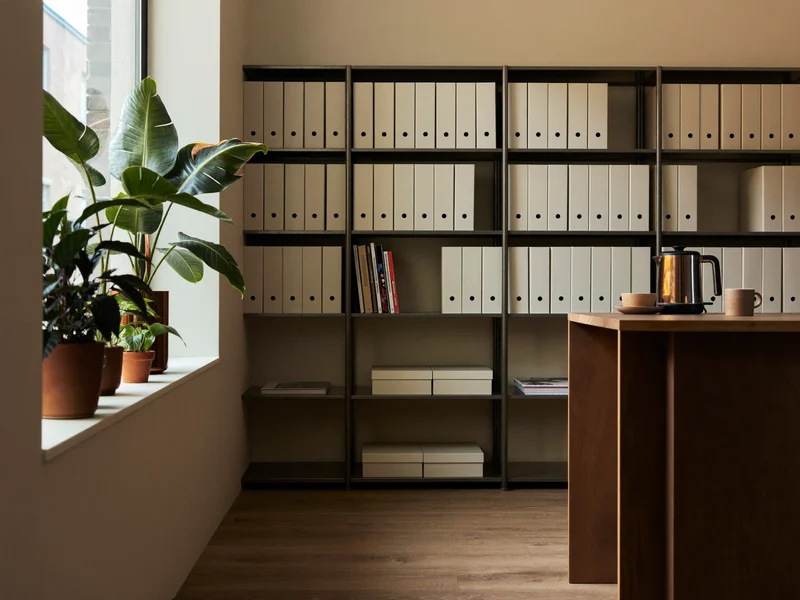 Illustration of a tidy resource room with folders, windowsill plants and a kettle